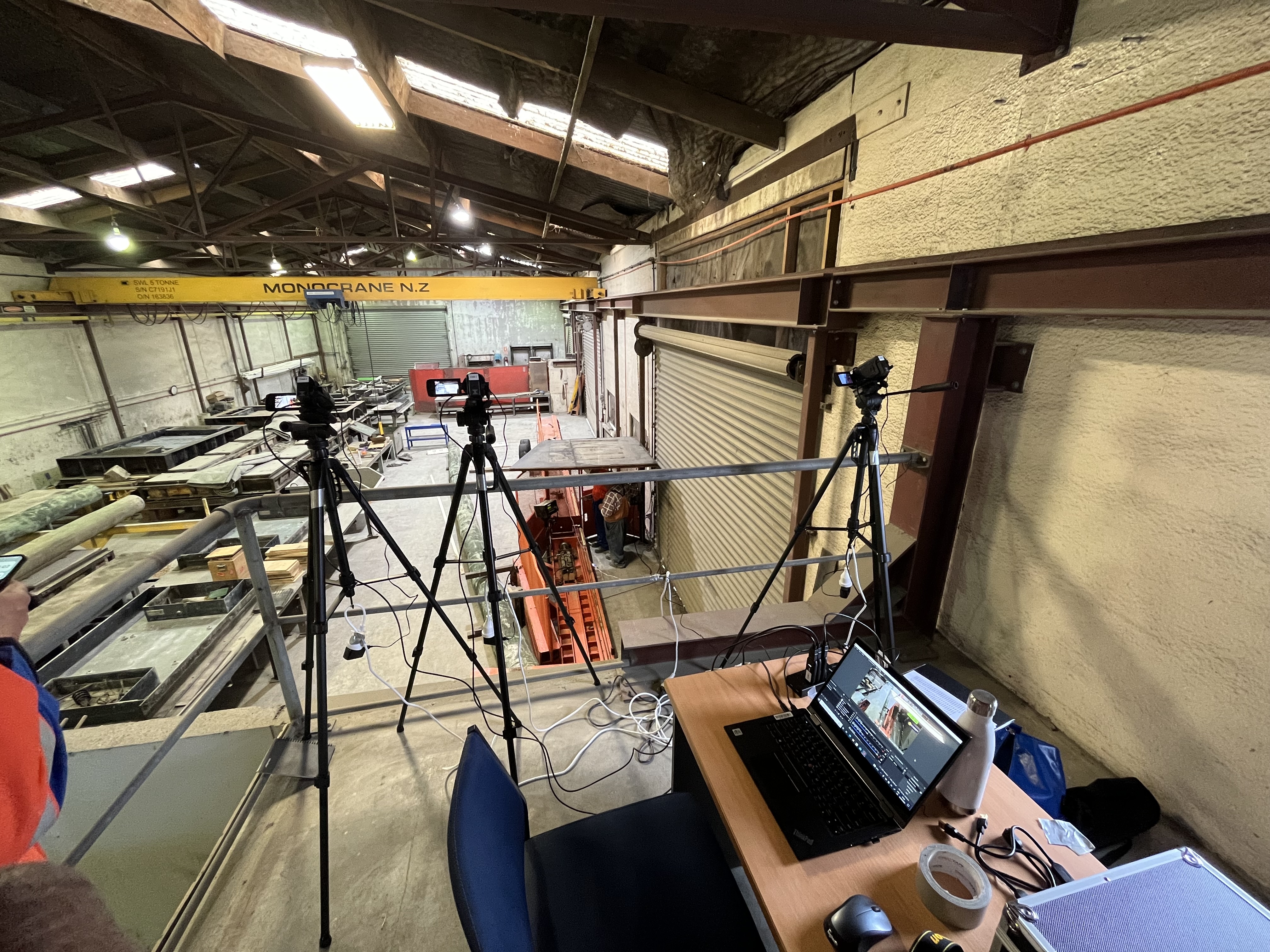 Controlled pole break test setup with cameras and laptops looking out over a pole