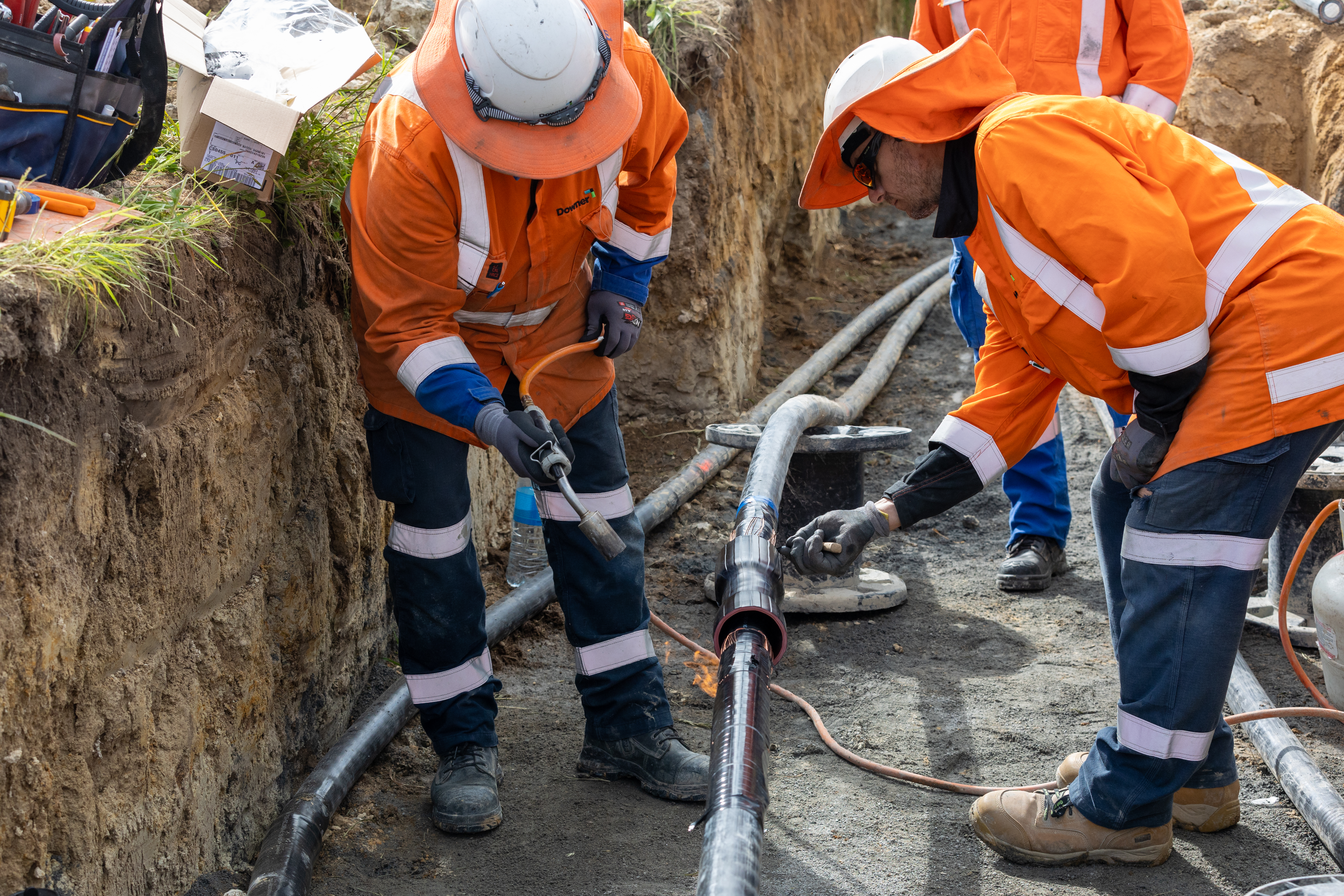 Field crews using a blowtorch to do cable jointing in a trench