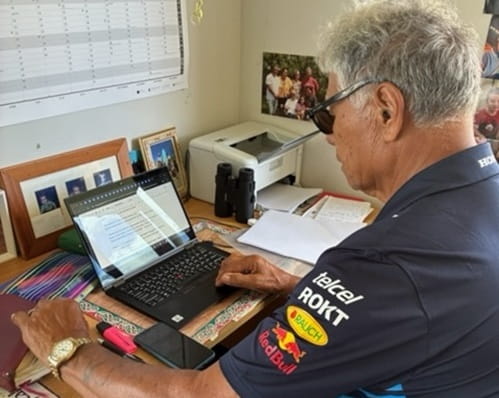 A elderly man working on a laptop