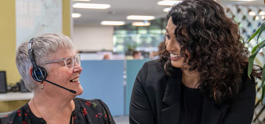 two women talking at office desk