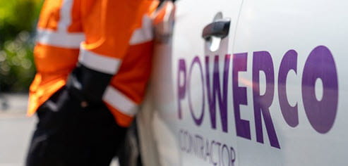 contractor standing next to Powerco branded vehicle