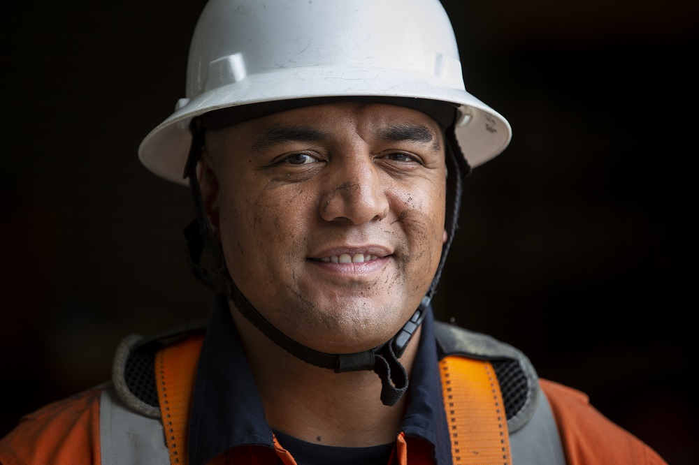 Portrait of Powerco contracted linesman, Pomare Samupo from Linespower, wearing a hardhat and overalls.
