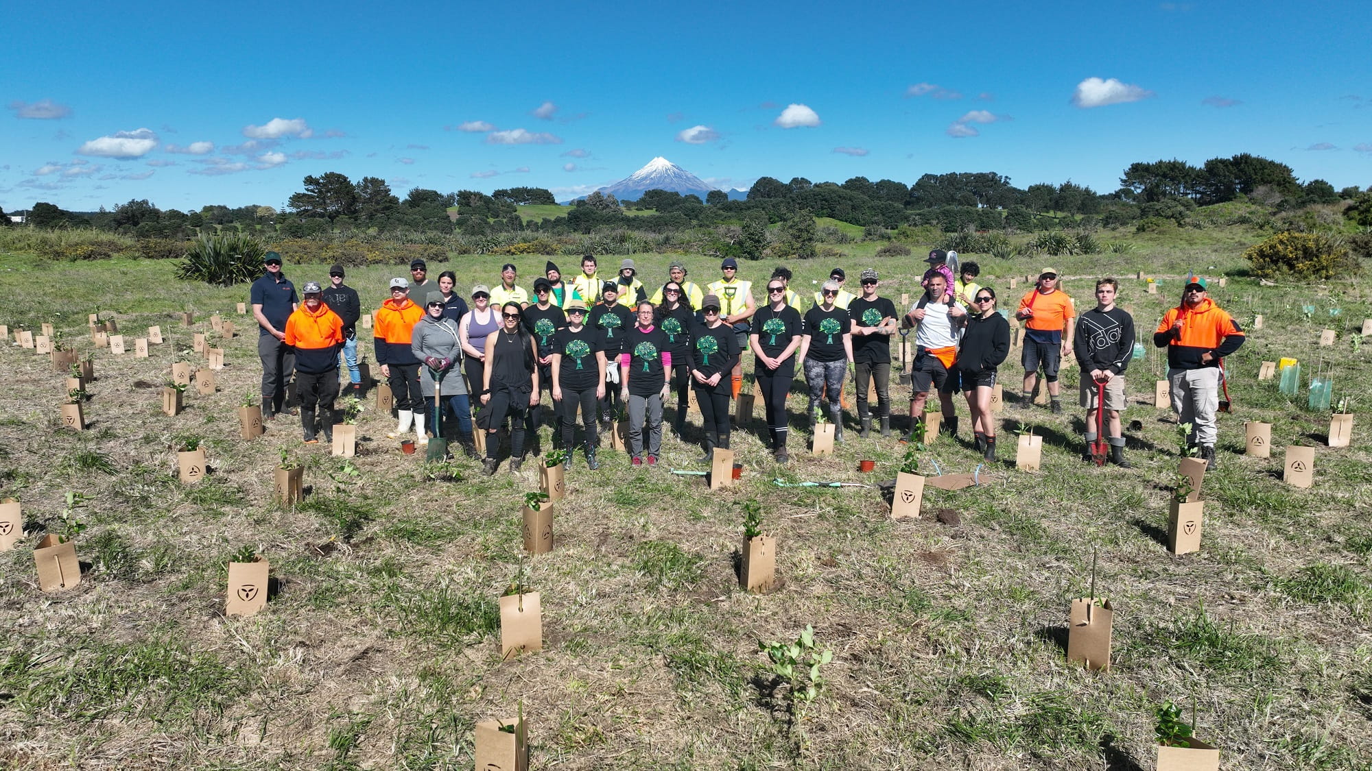 A group of volunteers planting trees on a piece of land at the mouth of New Plymouth's Waiwhakaiho River.