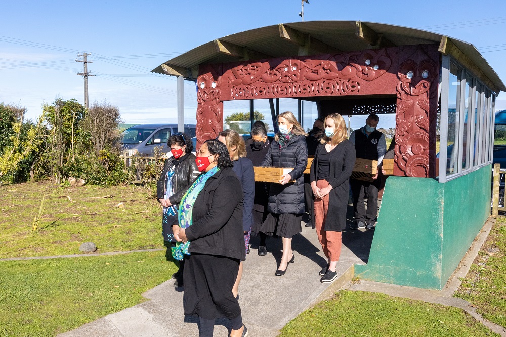 Powerco team members are welcomed into Te Kura o Ngaruahinerangi Tumuaki to donate the laptops.