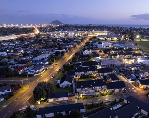 Aerial photograph over Mt Maunganui houses and streets at night with streetlights shining