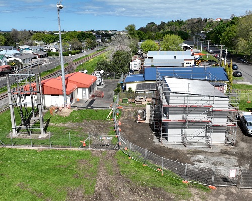 An aerial view of an electricity substation with two buildings - one is raised with scaffolding around it.