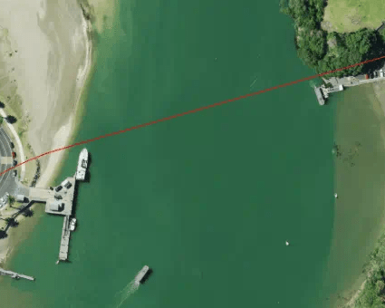 An aerial view of Whitianga Harbour with a red line between Whitianga and Cooks Beach showing where the underwater cable will be.