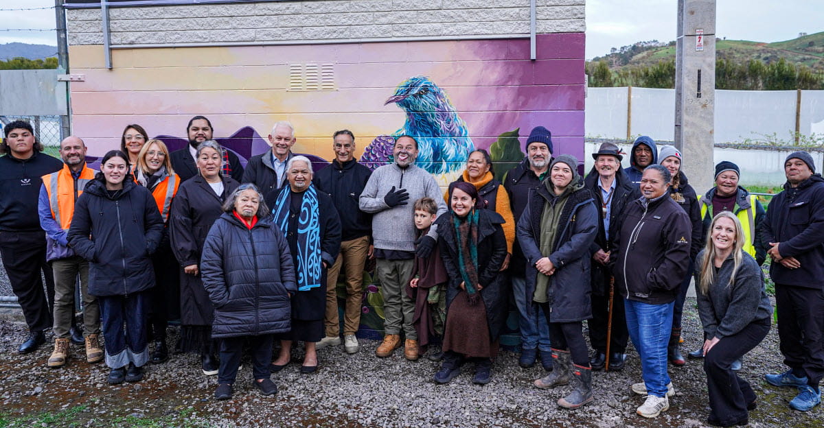 community members and Powerco staff standing in front of mural at Kauri Point substation