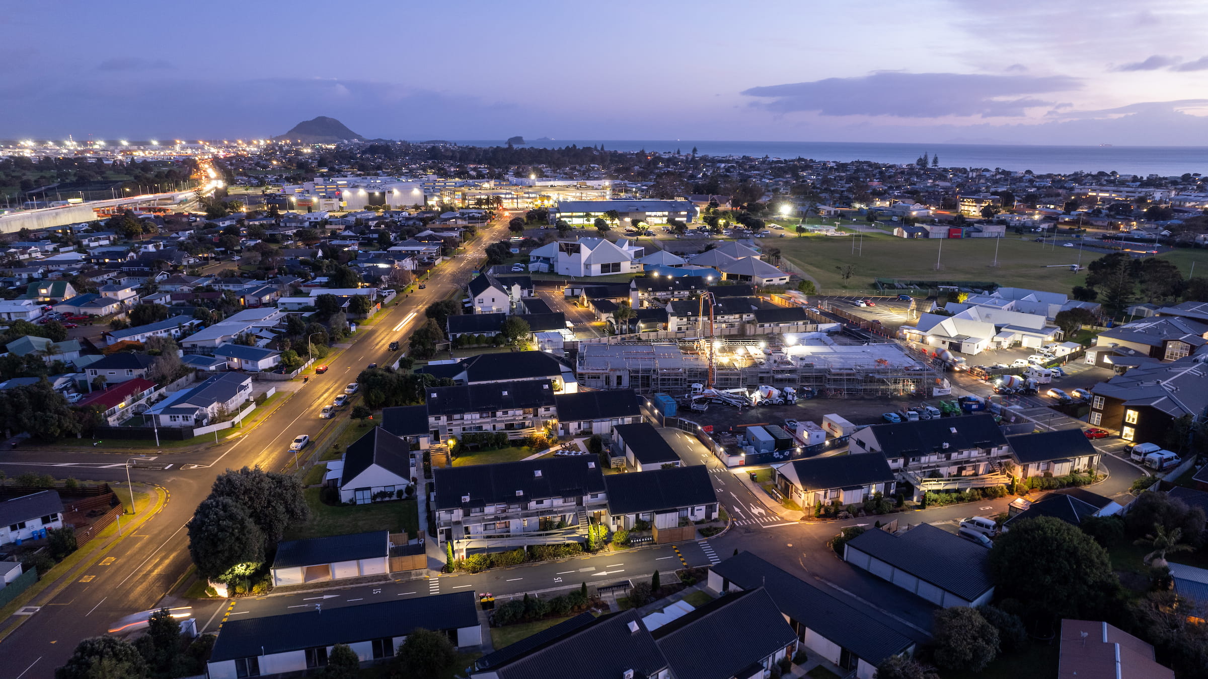 Aerial photograph of Western Bay of Plenty with Mt Maunganui in the background. At dusk with city lights.