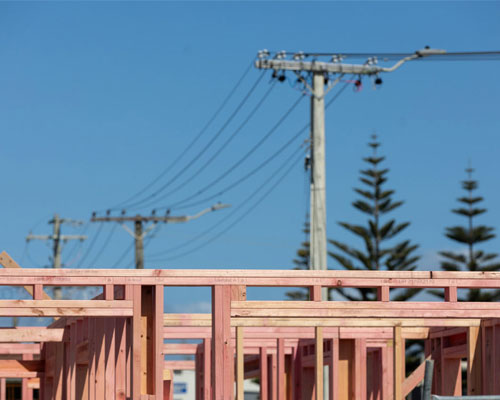 Power poles with a building being constructed in foreground
