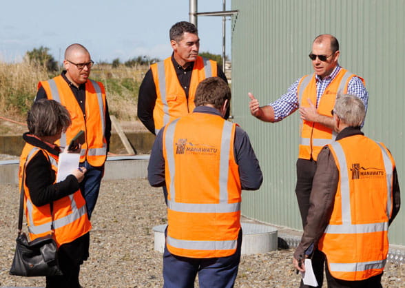 people talking in front of biogas digester