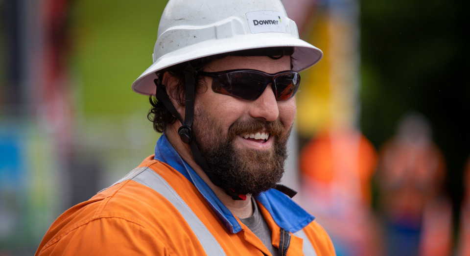 Downer crew member wearing PPE smiling 