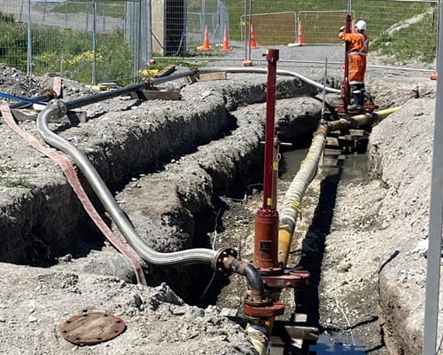 A man in PPE working on a circular gas bypass pipe