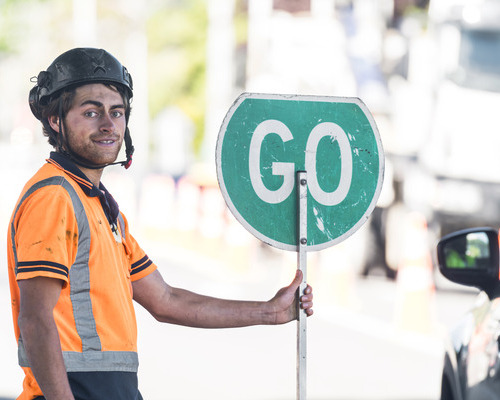 Traffic management staff holding a go sign