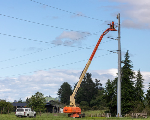 Field crew in cherry picker affixing line to overhead pole on the South Waikato National Grid Connection