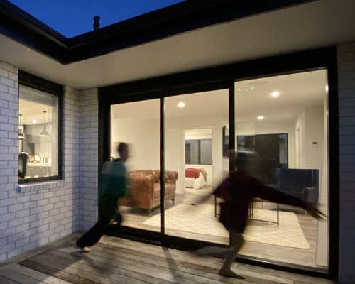 Kids running into a house lit by electricity