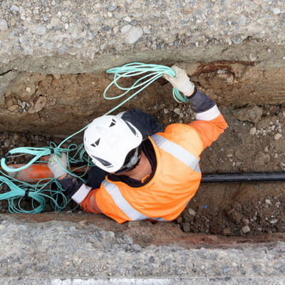 worker in trench working on electricity cable