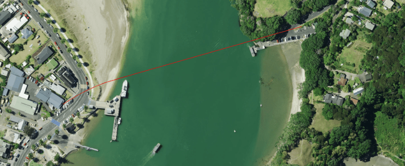 An aerial photo of Whitianga Harbour with a red line showing the route of the new marine electricity cable.